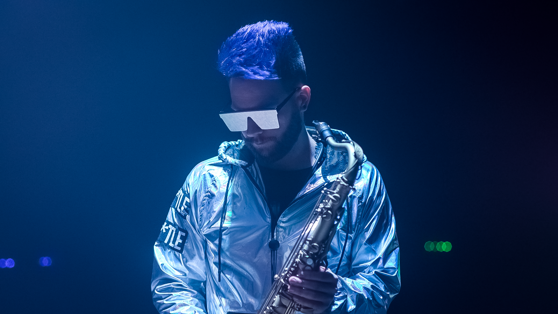 Lucas Sanor performing saxophone under stage lighting at a resort reception
